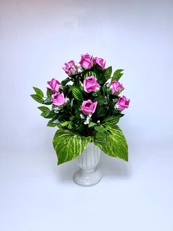 Różowo-zielona kompozycja nagrobna do wazonu z pąkami róż i dekoracyjnymi liśćmi.