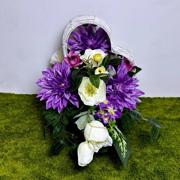 nowoczesny stroik ze sztucznych kwiatów kompozycja wielkanocna fioletowe serce biały kosz wiklinowy dalie anemony róże ostróżki jaskry kwiaty na cmentarz dekoracja nagrobna