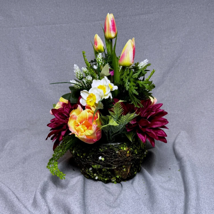 nowoczesny stroik ze sztucznych kwiatów różowe dalie kremowe róże tulipany jaskry koszyczek z mchu wiosenna kompozycja dekoracja wnętrz na cmentarz