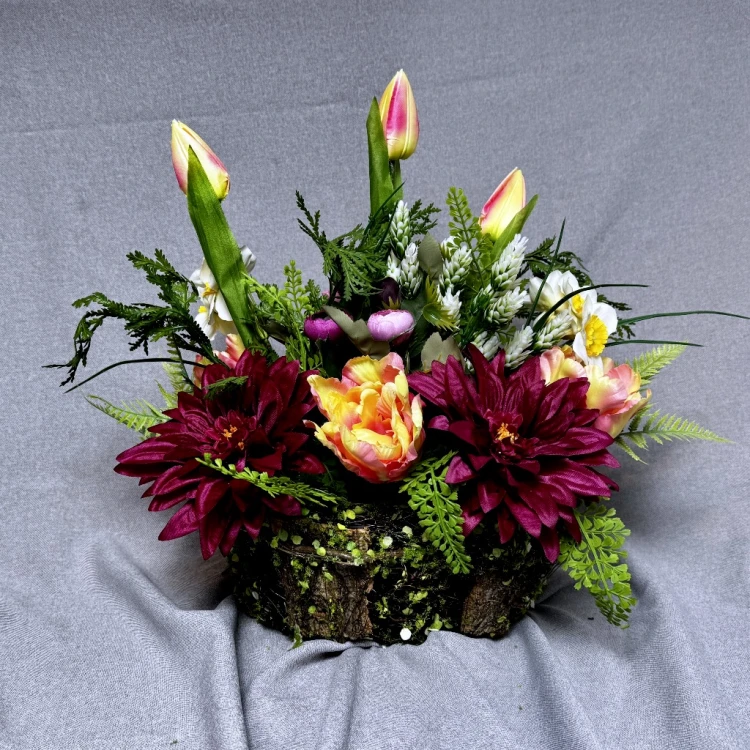 nowoczesny stroik ze sztucznych kwiatów różowe dalie kremowe róże tulipany jaskry koszyczek z mchu wiosenna kompozycja dekoracja wnętrz na cmentarz