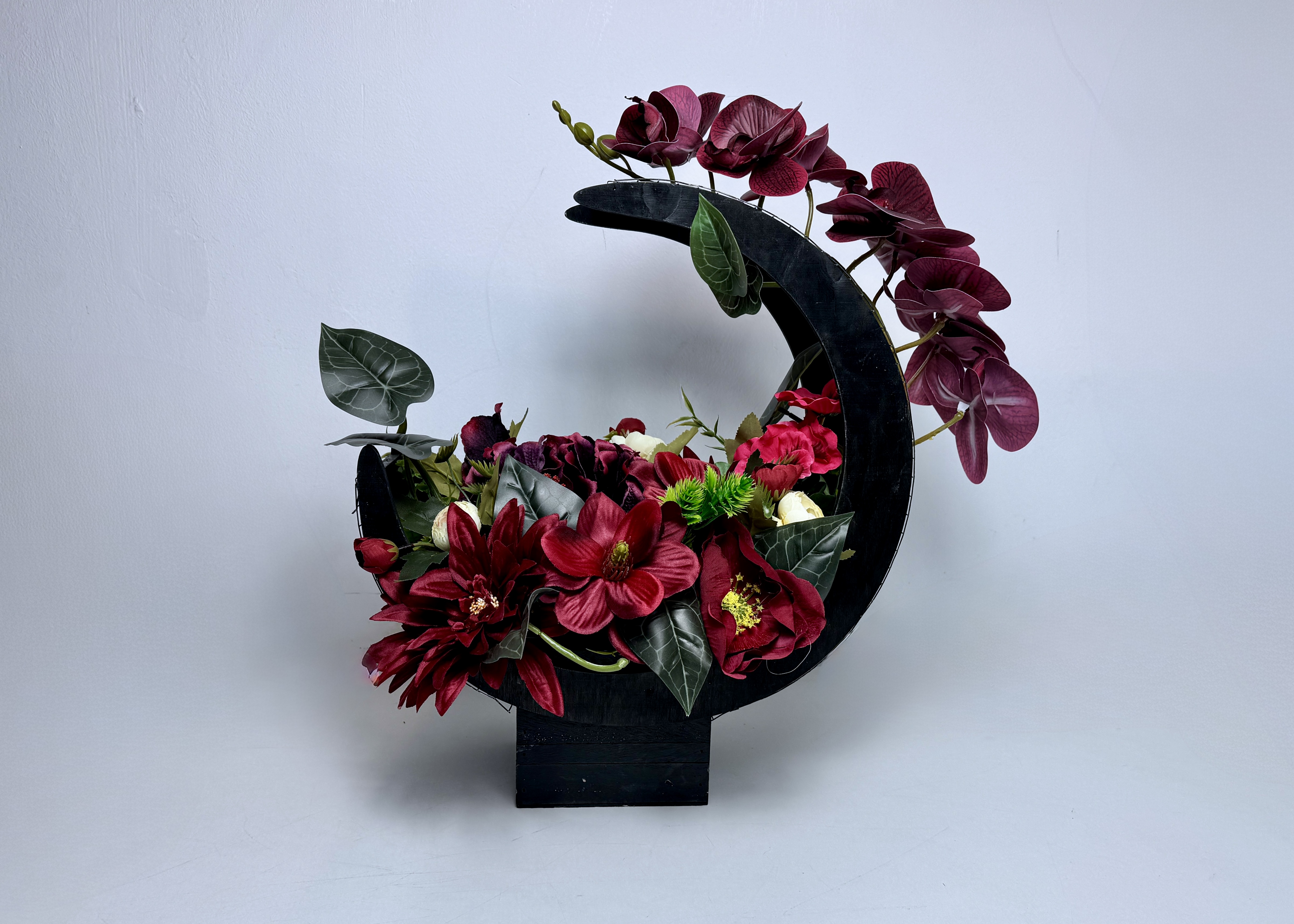 Elegancka kompozycja kwiatowa w czarnym koszu kolorze czerwieni i burgundu